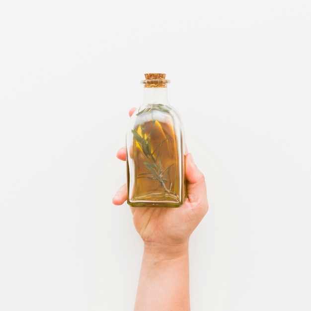 Hand with glass bottle of oil 