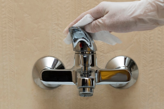 Hand with glove disinfecting faucet