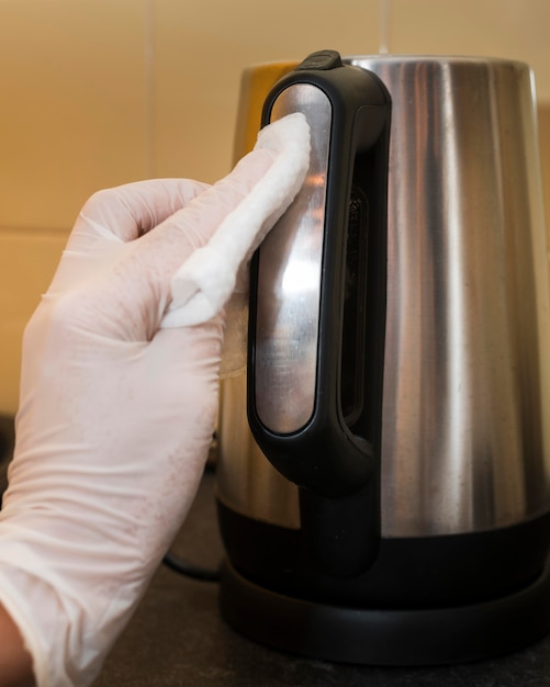 Free photo hand with glove disinfecting soap dispenser