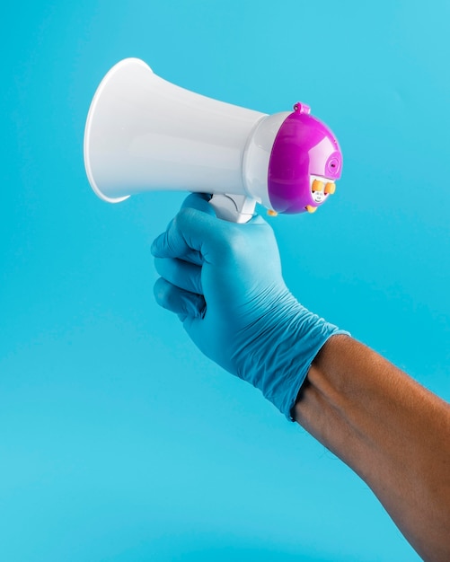 Hand with glove holding megaphone