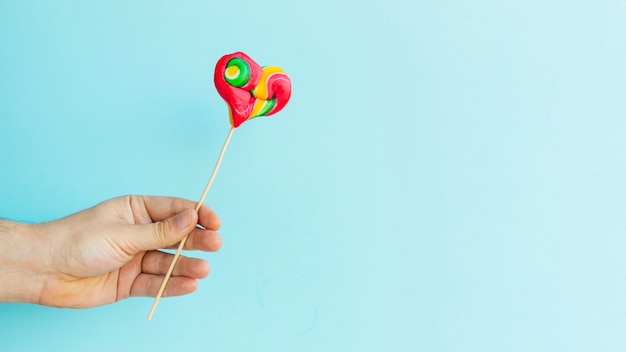 Free photo hand with heart lollipop