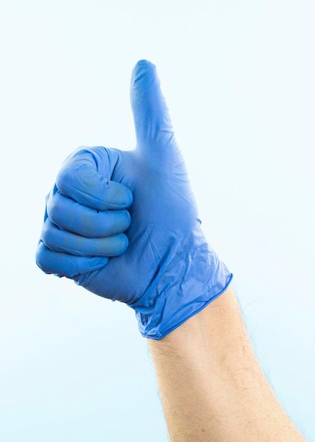 Hand with latex glove showing thumbs up