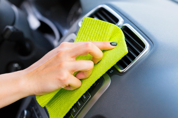 Hand with microfiber cloth cleaning car