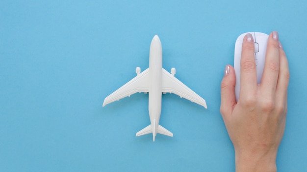 Hand with mouse beside airplane toy