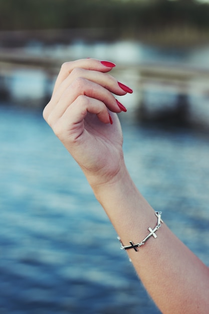 Free photo hand with painted nails and a bracelet