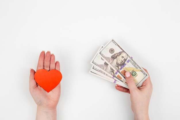 Free photo hand with paper heart and a gift box on a white background isolated flat lay