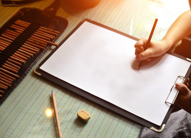 Hand with a pen writing on a blank sheet