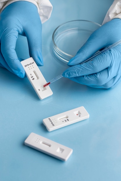 Hand with protective gloves making covid test with a petri dish