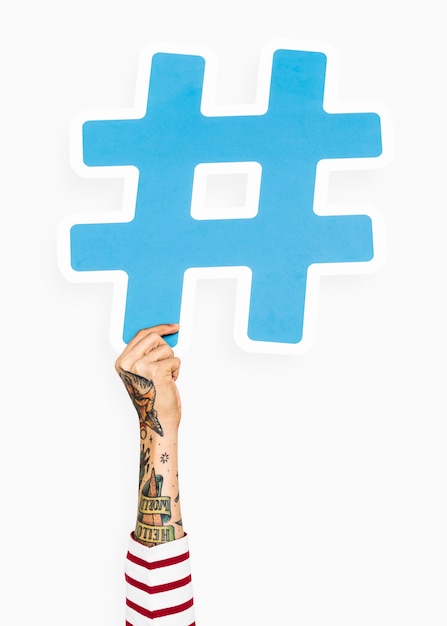 Free photo hand with tattoo holding hashtag icon