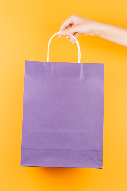 Free photo hand with violet shopping packet