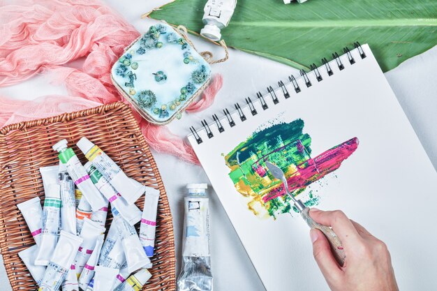 Hand of woman drawing painting picture with oil paints.