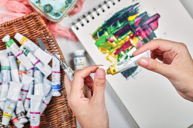 Hand of woman drawing painting picture with oil paints.