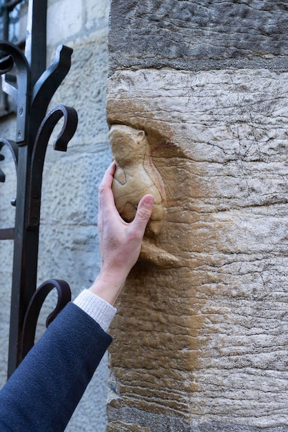 Hand of woman on famous sculpture of owl on NotreDamedeDijon