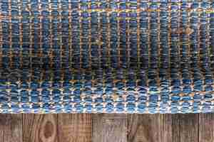 Foto gratuita tappeto di denim geometrico tessuto a mano su pavimento di legno