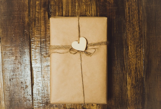Подарочная коробка ручной работы с красным сердцем на деревянном столе Вид сверху