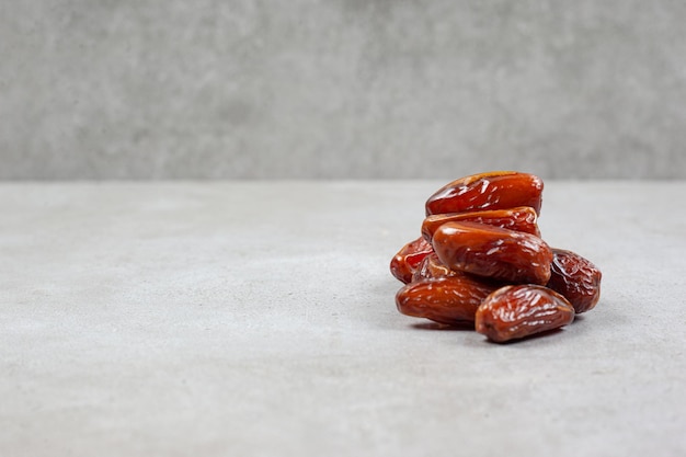 Free photo a handful of fresh dates on marble background.