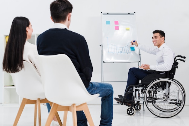 Free photo handicapped young businessman giving presentation to business colleague