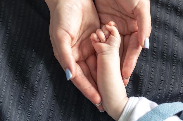 Foto gratuita la maniglia di un neonato nelle mani di un primo piano della nonna