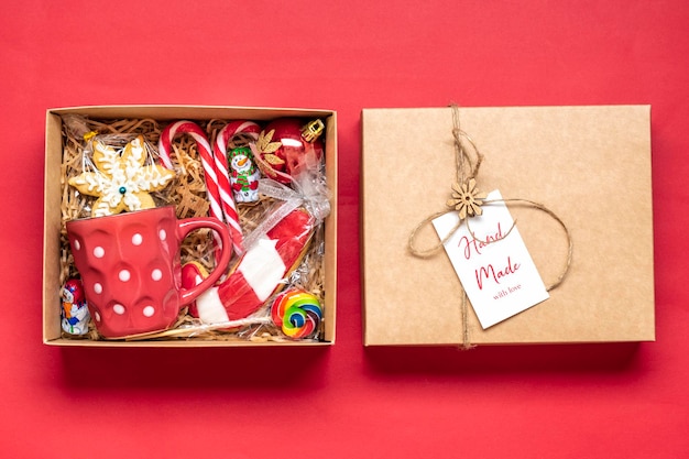Handmade care package seasonal gift box with candies cup on red table