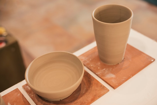 Handmade clay bowl and glass on table