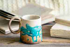 Free photo handmade cup and books closeup on a wooden surface