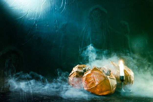 Handmade Halloween pumpkins with burning candle and ghost and smoke