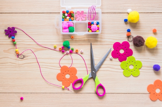 Handmade jewelry made with beads and flower patch on wooden backdrop