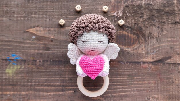 Handmade knitted toy for kids with wooden letters composing word love. Top view