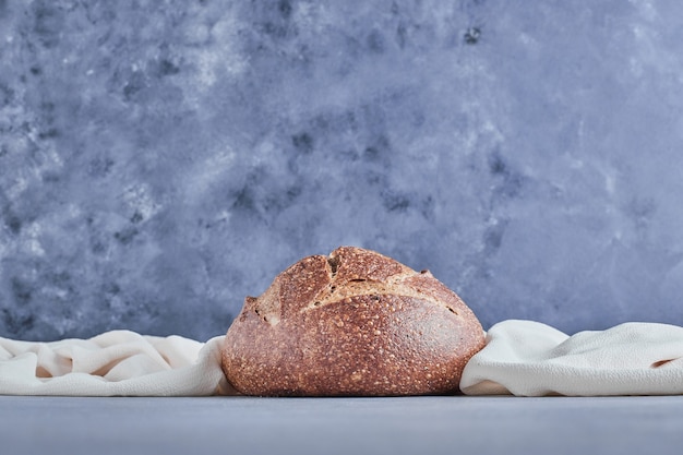 Free photo handmade round bread bun on blue table.