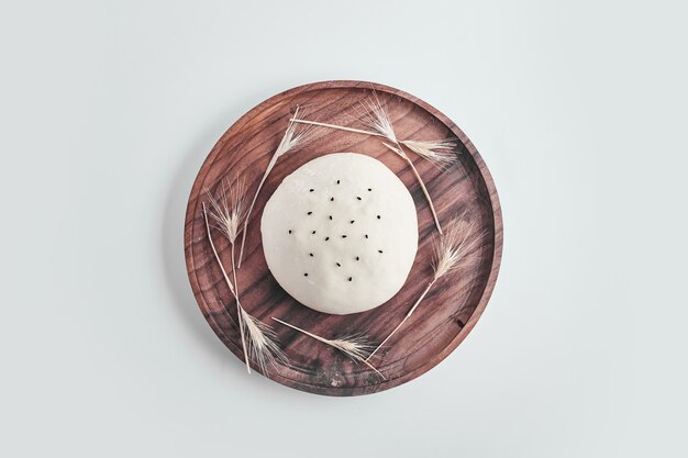 Handmade round bread bun dough in a wooden platter.