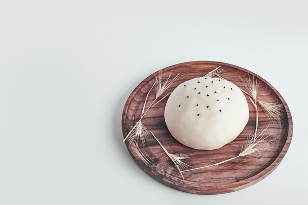 Handmade round bread bun dough in a wooden platter.