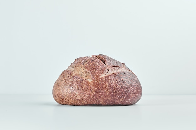 Handmade round bread bun on grey table.