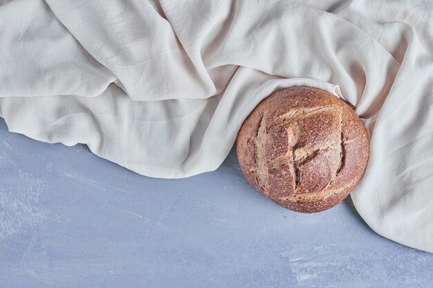 Handmade round bread bun on the tablecloth.