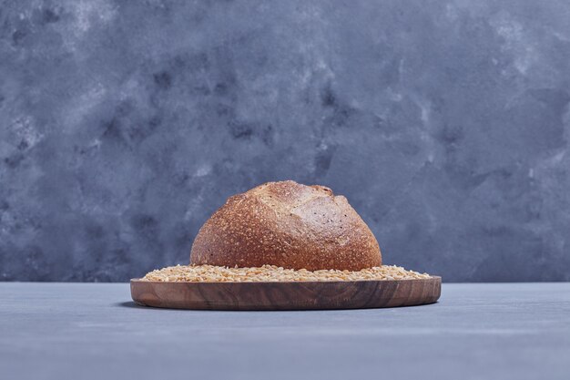 Handmade round bread bun on the wheat platter.