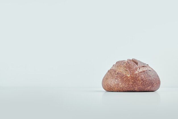 Handmade round bread on grey table .