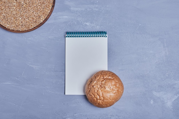 Handmade round bread with a recipe book aside.