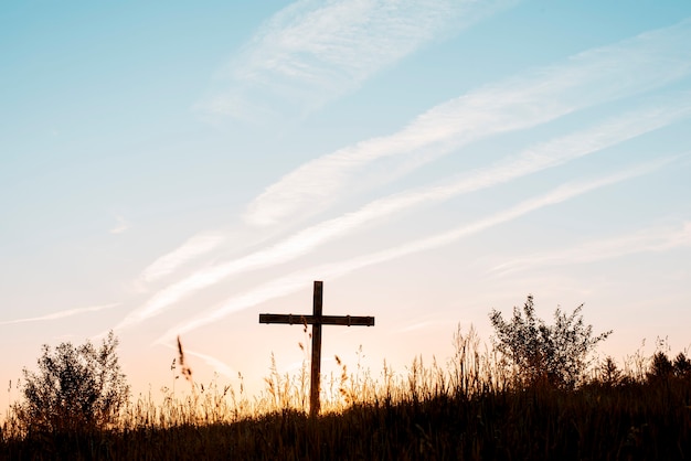 A handmade wooden cross in the filed under a blue sky