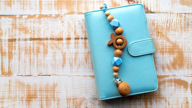 Handmade wooden decoration on the blue wallet. Top view