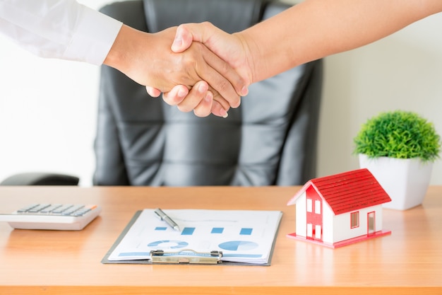 hands of agent and client shaking hands after signed contract buy new apartment.