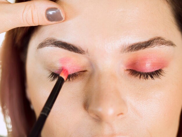 Hands applying eyeshadow front view