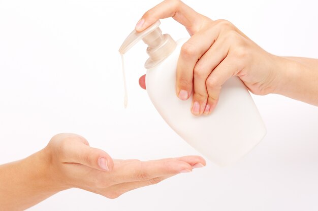 흰 액체 비누를 적용하는 손