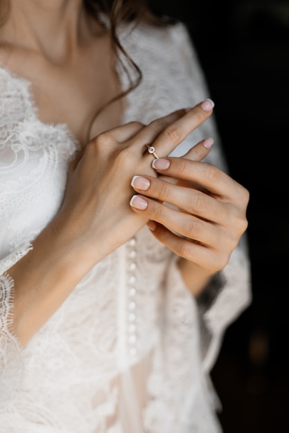 Hands of a bride with tender engagement ring on