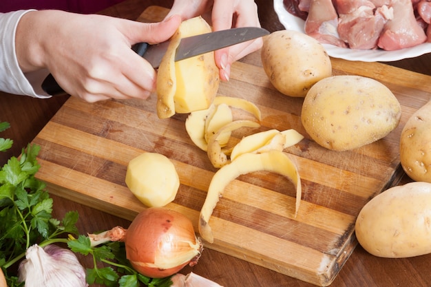 Foto gratuita mani che puliscono le patate