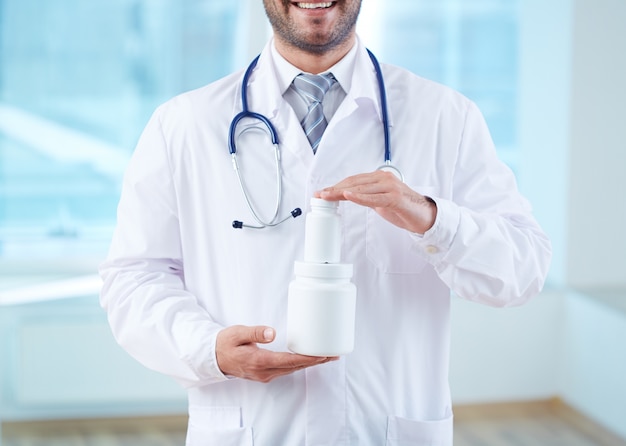 Hands close-up of doctor holding two containers