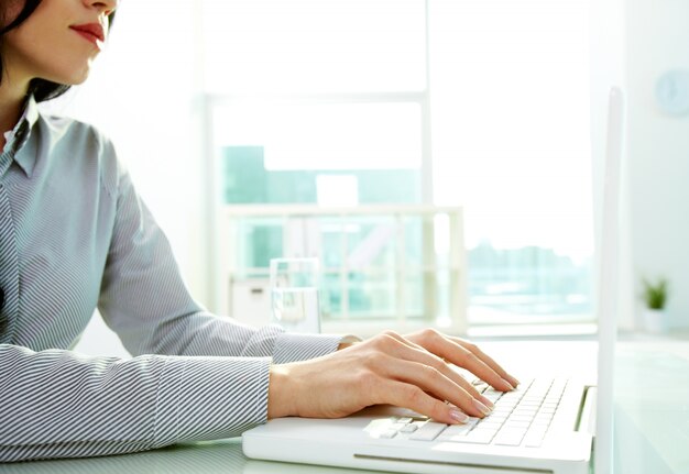 Hands close-up of young woman using a laptop