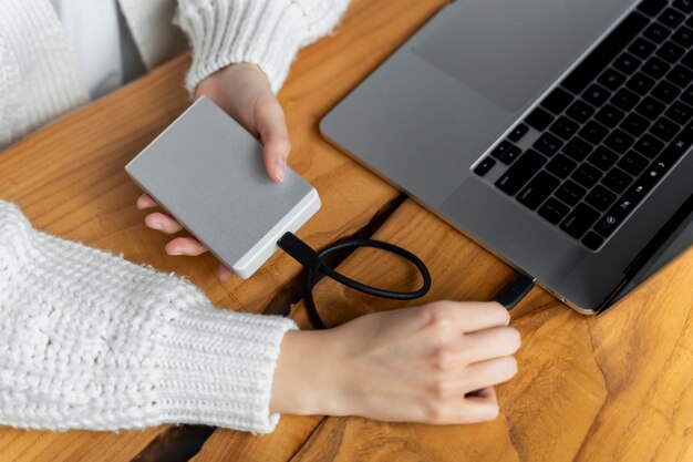 Руки подключают ssd к ноутбуку под высоким углом