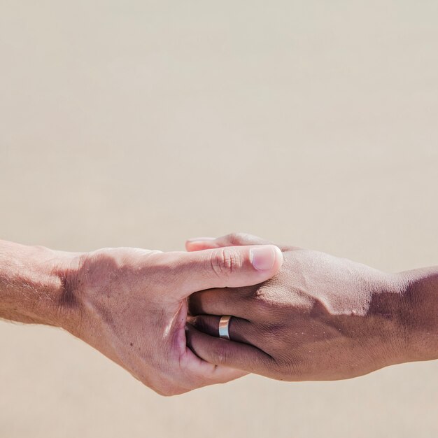 Hands of couple at the beach