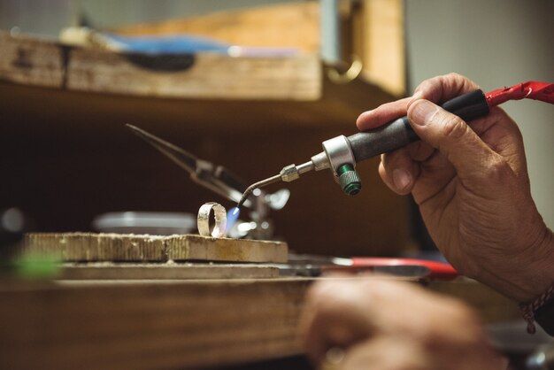 블로우 토치를 사용하는 craftswoman의 손