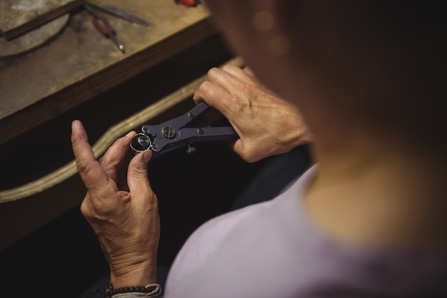 Hands of craftswoman using pliers