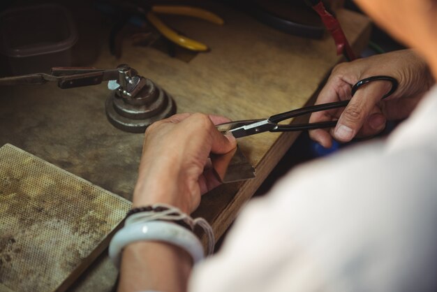 Hands of craftswoman using scissors